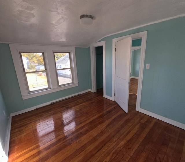 unfurnished bedroom featuring dark wood-type flooring and lofted ceiling