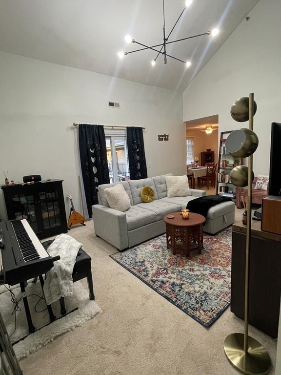 living room featuring carpet floors, high vaulted ceiling, and a notable chandelier