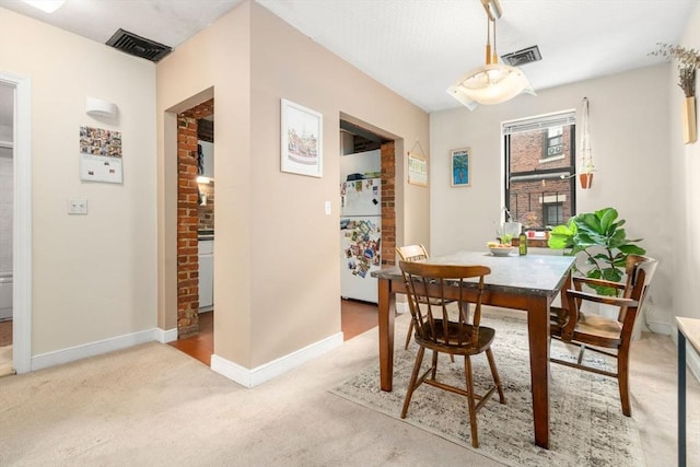 carpeted dining room featuring baseboards