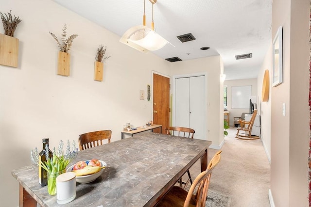 dining space featuring light carpet and baseboards
