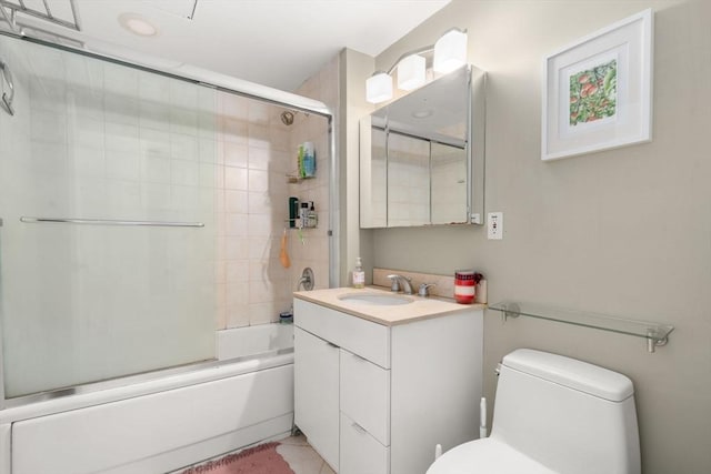 bathroom featuring toilet, enclosed tub / shower combo, and vanity
