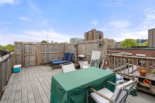 wooden terrace with outdoor dining area and fence