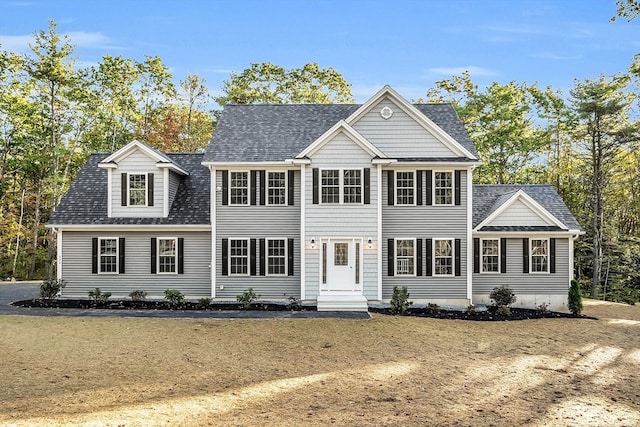 colonial inspired home featuring a front lawn