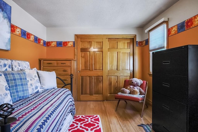 241 Broadway Rd Unit 56, Dracut, MA 01826 - bedroom with light wood finished floors and a textured ceiling