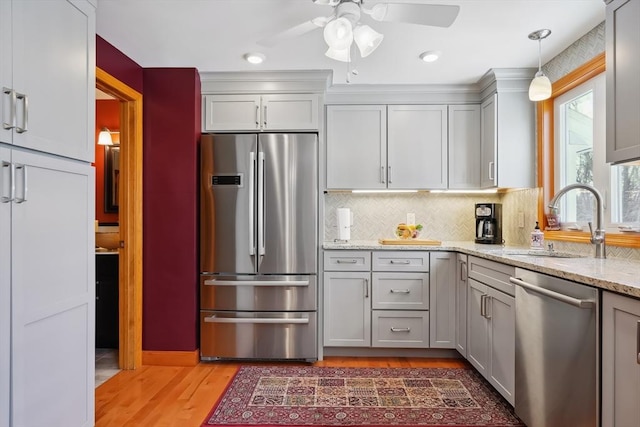 241 Broadway Rd Unit 56, Dracut, MA 01826 - kitchen featuring stainless steel appliances, a sink, light wood-type flooring, backsplash, and light stone countertops
