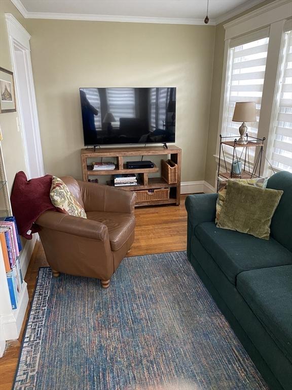 452 W Clinton St, New Bedford, MA 02740 - living area featuring wood finished floors, crown molding, and baseboards