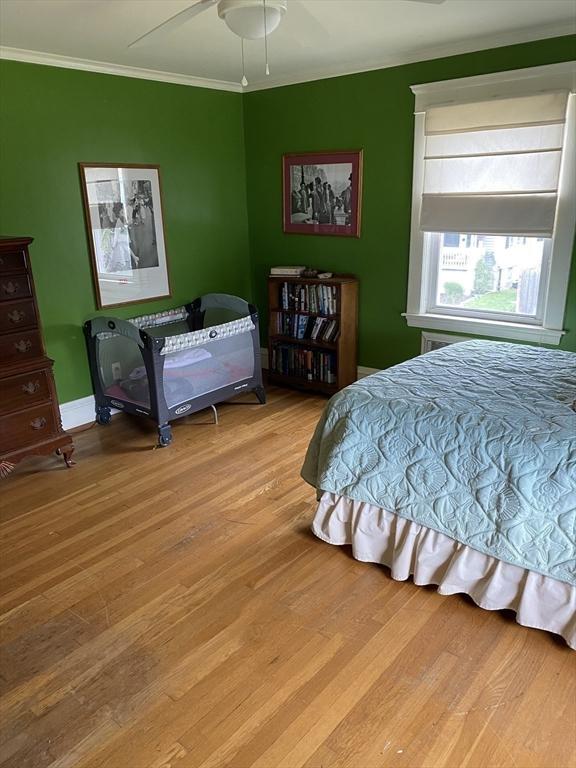 452 W Clinton St, New Bedford, MA 02740 - bedroom with wood finished floors, ornamental molding, a ceiling fan, and baseboards