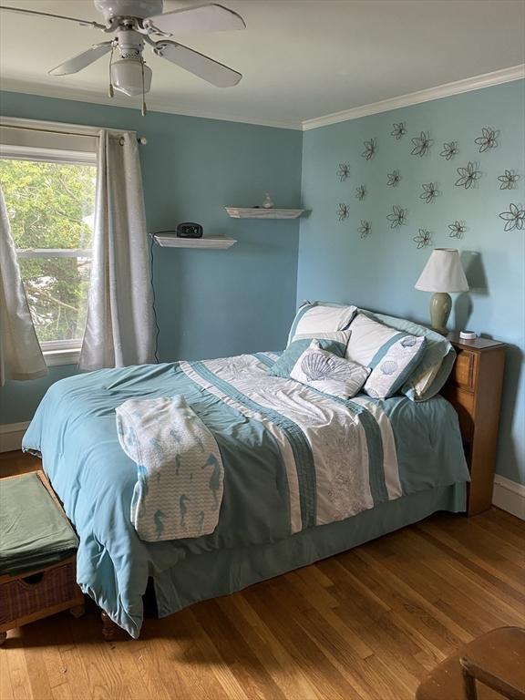 452 W Clinton St, New Bedford, MA 02740 - bedroom with wood finished floors, ornamental molding, ceiling fan, and baseboards