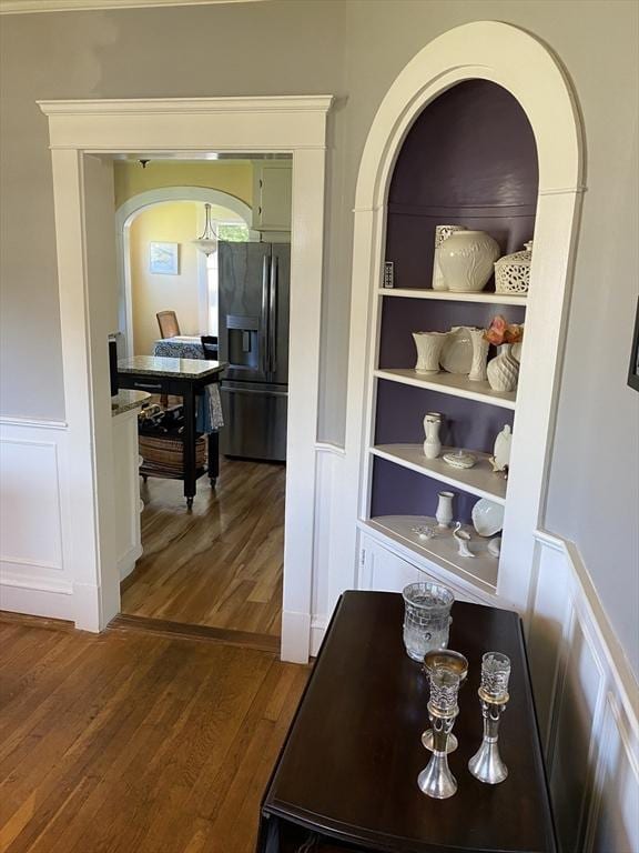 452 W Clinton St, New Bedford, MA 02740 - hallway with wood finished floors, a decorative wall, arched walkways, built in shelves, and wainscoting