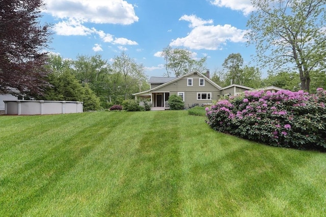 21 Witherell Pl, Plainville, MA 02762 - rear view of house featuring a lawn, an outdoor pool, and a chimney