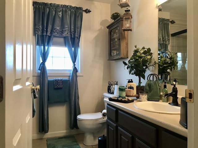 bathroom featuring tile patterned flooring, vanity, walk in shower, and toilet