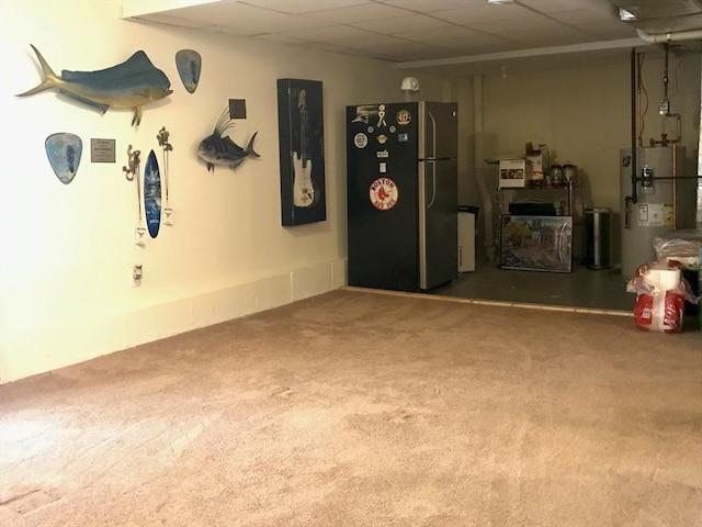 garage featuring water heater and stainless steel refrigerator