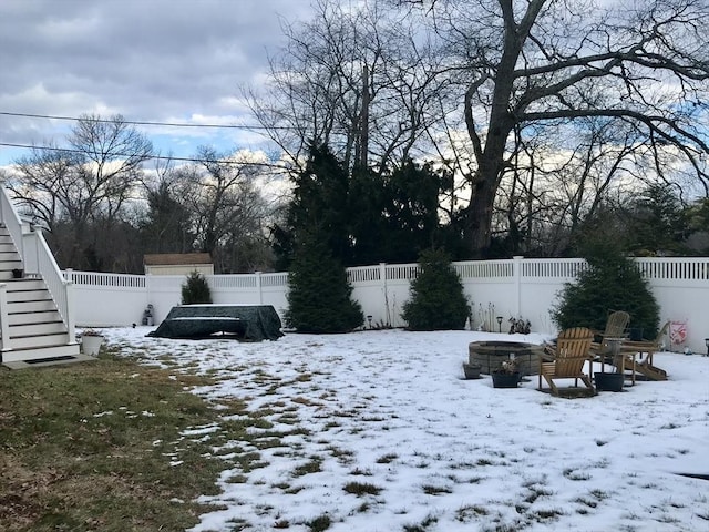 yard layered in snow with a fire pit