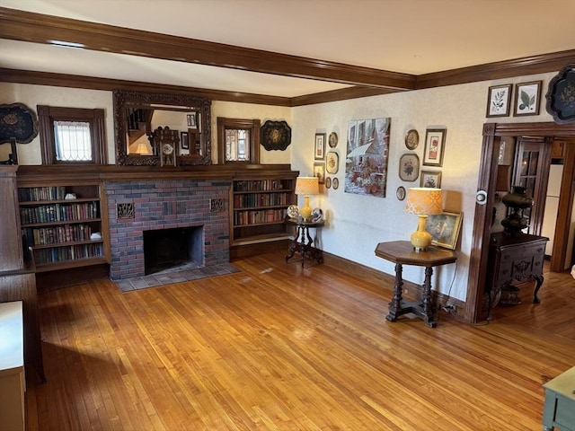 living room with a brick fireplace, wood-type flooring, ornamental molding, and beamed ceiling