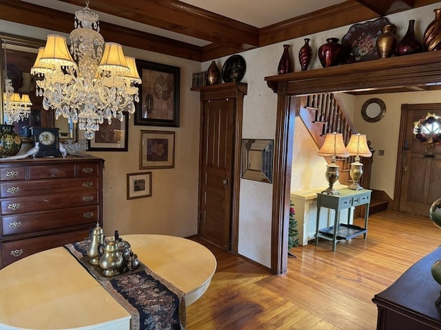 dining area with beam ceiling, light hardwood / wood-style floors, and a notable chandelier