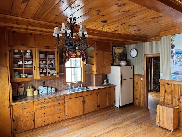 kitchen with sink, wood ceiling, white refrigerator, pendant lighting, and light hardwood / wood-style floors