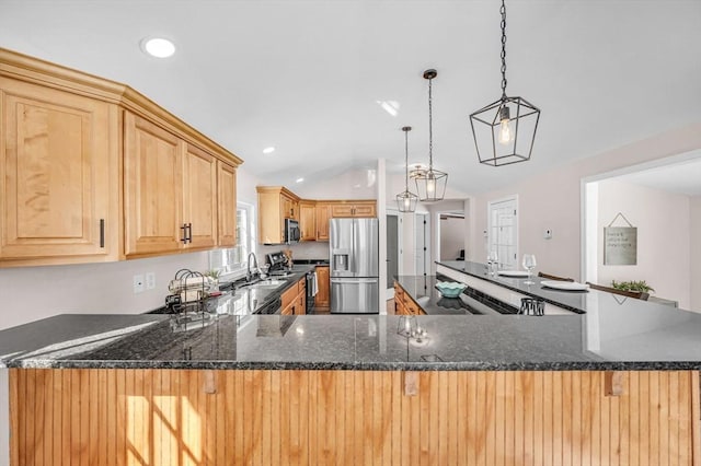 kitchen with hanging light fixtures, a peninsula, appliances with stainless steel finishes, and light brown cabinetry