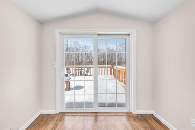 doorway to outside featuring vaulted ceiling, baseboards, and wood finished floors