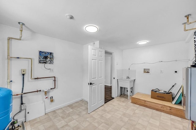 laundry area featuring laundry area, washer hookup, a sink, light floors, and electric dryer hookup