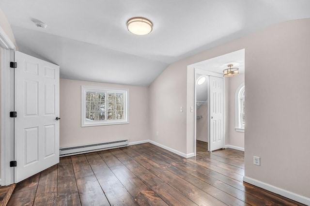 additional living space with lofted ceiling, dark wood-type flooring, baseboard heating, and baseboards