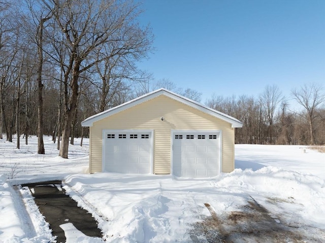 snow covered garage with a garage