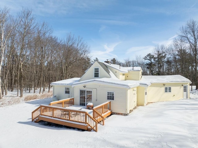 snow covered house featuring a wooden deck