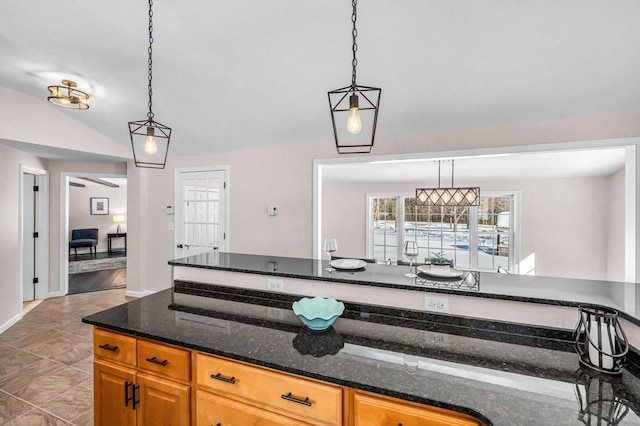 kitchen with dark stone counters and pendant lighting