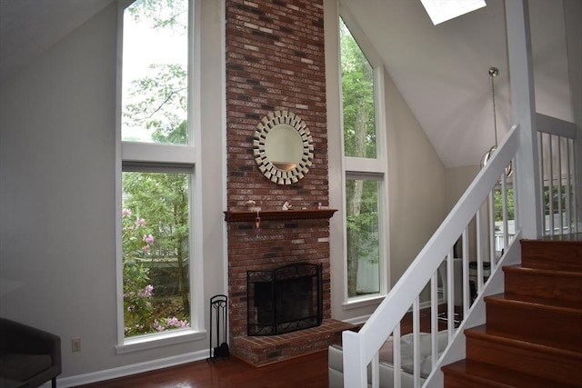 16 Sherborne Cir, Ashland, MA 01721 - stairs with wood finished floors, high vaulted ceiling, a fireplace, a skylight, and baseboards