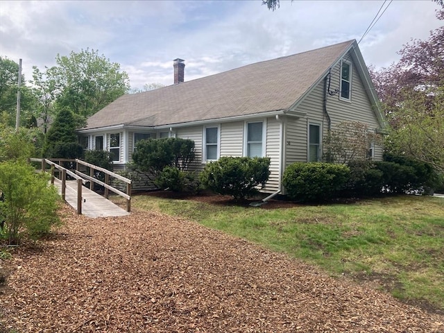 view of home's exterior featuring a shingled roof and a chimney