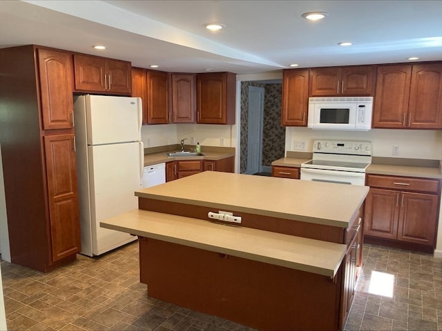 kitchen featuring a sink, white appliances, light countertops, recessed lighting, and a kitchen island