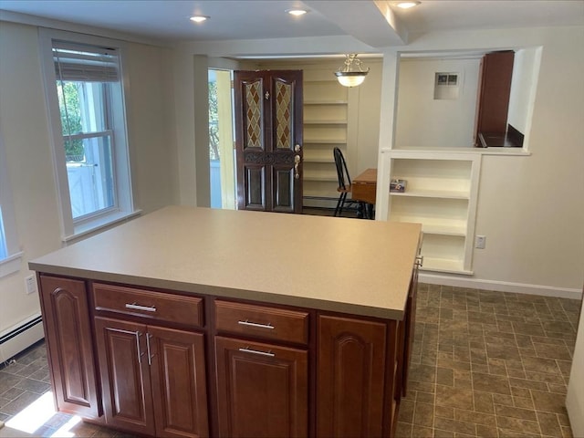 kitchen with a center island, light countertops, baseboards, a baseboard heating unit, and recessed lighting