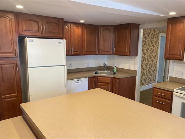 kitchen featuring a sink, recessed lighting, wallpapered walls, and white appliances