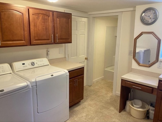 washroom featuring light floors, cabinet space, independent washer and dryer, and baseboards