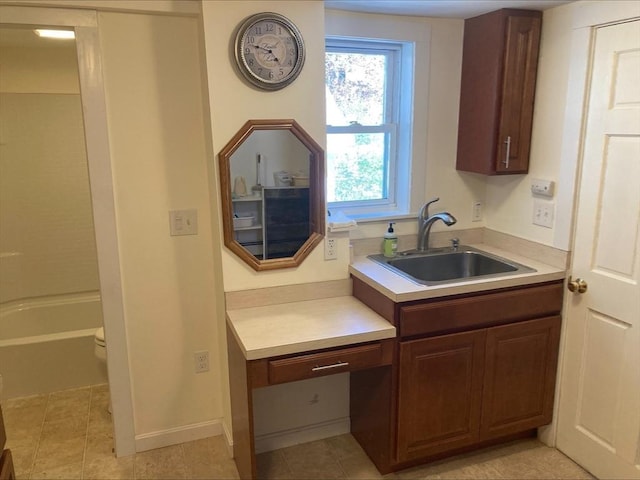 kitchen with a sink, light tile patterned floors, and light countertops