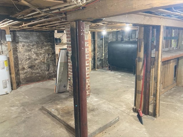 unfinished below grade area featuring heating fuel and electric water heater