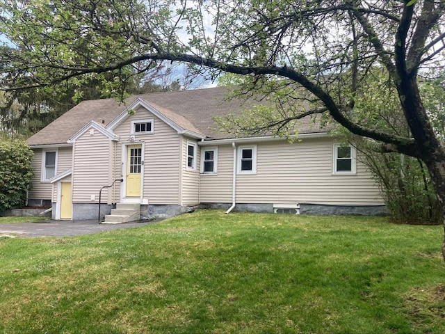 rear view of house with a yard and entry steps