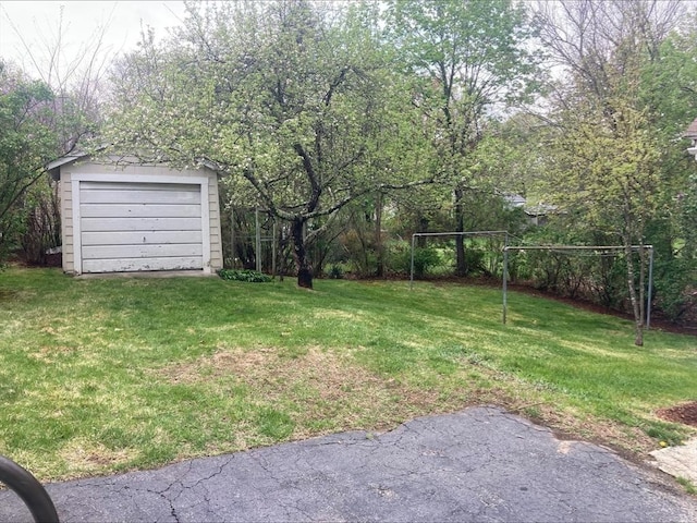 view of yard featuring a detached garage and an outdoor structure