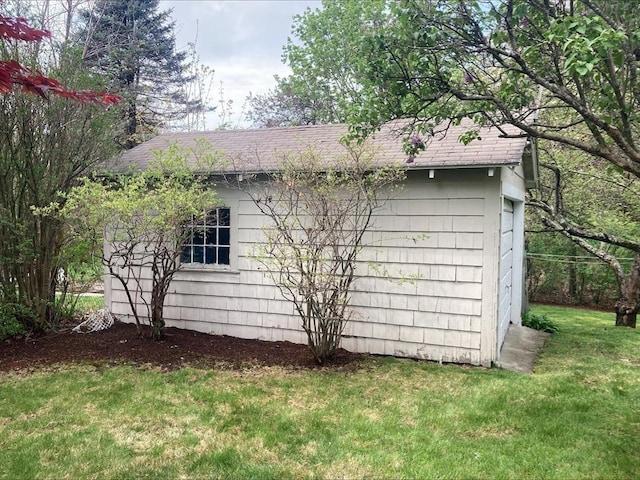 view of home's exterior with roof with shingles and a yard