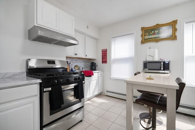 32 Slater St, Fall River, MA 02720 - kitchen with stainless steel appliances, under cabinet range hood, white cabinets, light countertops, and decorative backsplash