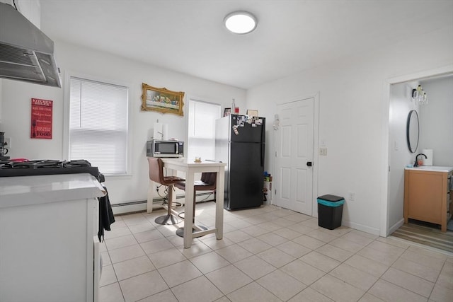 32 Slater St, Fall River, MA 02720 - kitchen with freestanding refrigerator, wall chimney range hood, stainless steel microwave, light countertops, and light tile patterned flooring