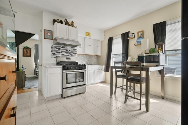 32 Slater St, Fall River, MA 02720 - kitchen featuring appliances with stainless steel finishes, exhaust hood, tasteful backsplash, white cabinetry, and light countertops