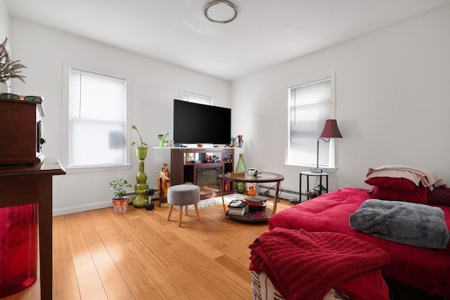 32 Slater St, Fall River, MA 02720 - bedroom featuring multiple windows, wood finished floors, a glass covered fireplace, and a baseboard radiator