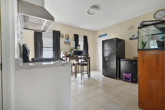 32 Slater St, Fall River, MA 02720 - kitchen featuring range hood, freestanding refrigerator, light tile patterned floors, and a desk