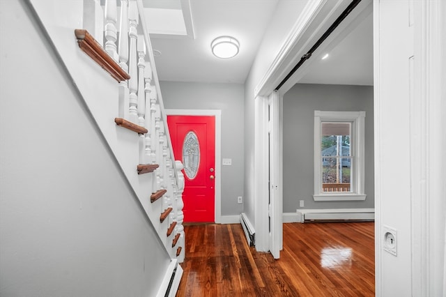 foyer entrance featuring baseboard heating, a barn door, and dark hardwood / wood-style floors