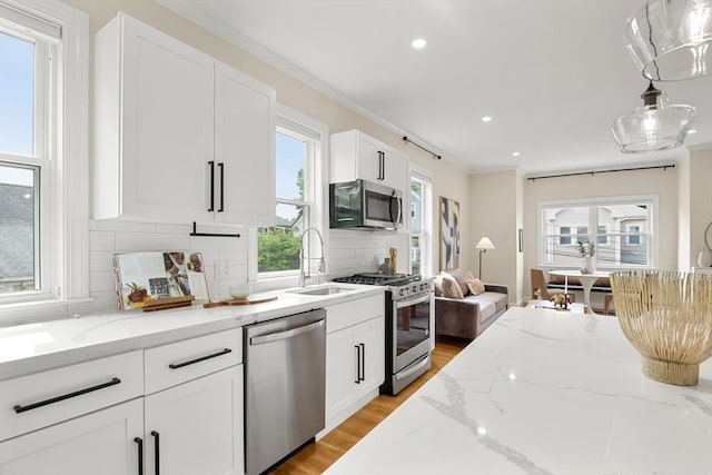 34 Leniston St Unit 2, Boston, MA 02131 - kitchen featuring appliances with stainless steel finishes, a sink, backsplash, light wood-style floors, and recessed lighting