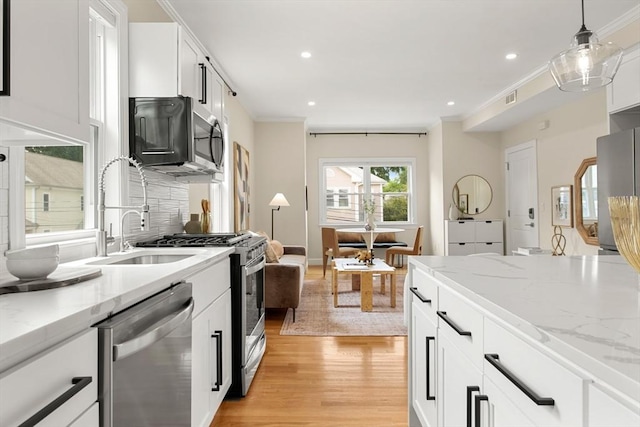 34 Leniston St Unit 2, Boston, MA 02131 - kitchen featuring stainless steel appliances, light wood-style flooring, ornamental molding, recessed lighting, and hanging light fixtures