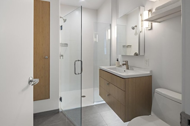 bathroom with a shower with door, vanity, tile patterned flooring, and toilet