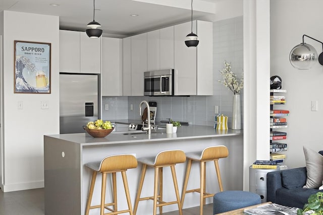 kitchen with white cabinetry, pendant lighting, and stainless steel appliances