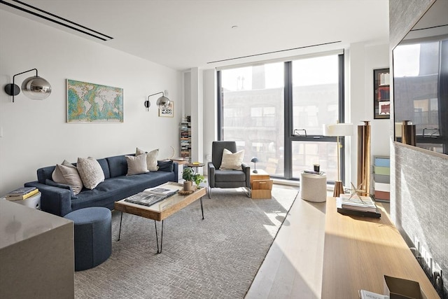 living room featuring wood-type flooring and a wall of windows