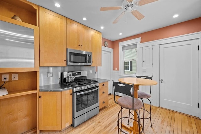 kitchen with light wood finished floors, stainless steel countertops, stainless steel appliances, a ceiling fan, and recessed lighting